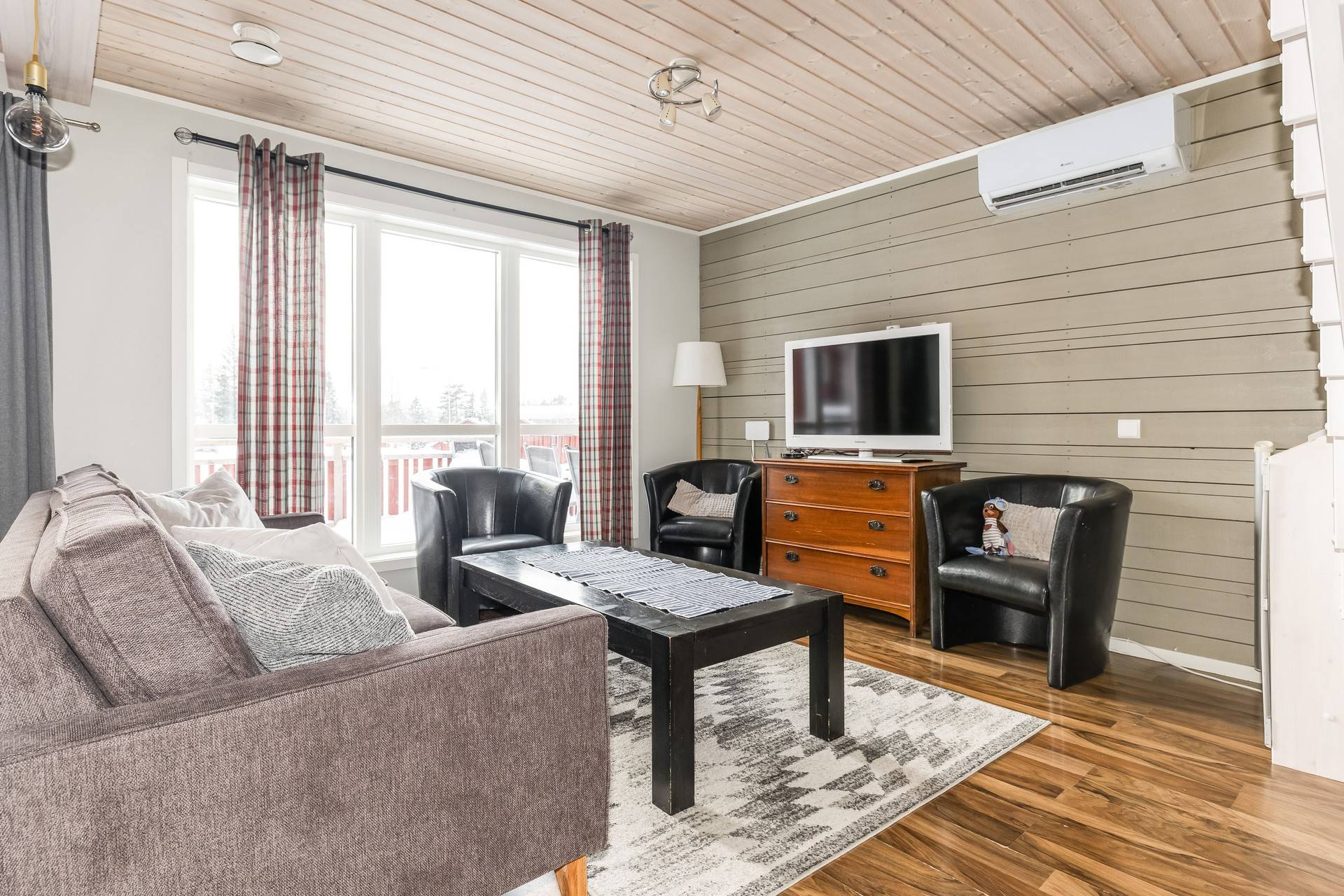 Vardagsrum med fåtöljer, soffa. Värmepump som ger både kyla & värme. 